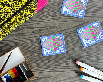 Könnte beinhalten: Drei blaue Aufkleber mit dem Text "GET SOME PERSPECTIVE" und einem geometrischen Design in Pink und Grün. Ein gelb-schwarz gemustertes Notizbuch, ein Aquarellfarbkasten und farbige Marker sind ebenfalls zu sehen.