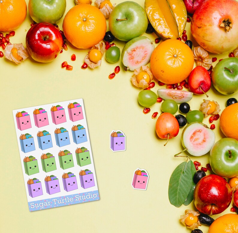 Pode incluir: Uma folha de autocolantes coloridos com sacos de presente sorridentes com cenouras em cima. Os autocolantes s&atilde;o rosa, azul, verde e roxo. O fundo &eacute; uma superf&iacute;cie amarela com v&aacute;rias frutas, incluindo laranjas, ma&ccedil;&atilde;s e rom&atilde;s. O texto "Sugar Turtle Studio" est&aacute; na folha.