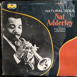Op de afbeelding: Een zwart-witfoto van Nat Adderley die trompet speelt. De albumhoes is voor het album "Natural Soul" en bevat de tekst "Milestone" en "MSP 9009".