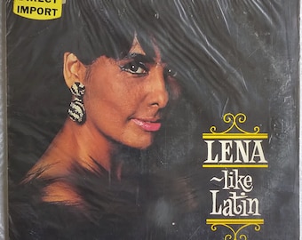May include: A vinyl record cover featuring a woman with dark hair and large earrings. The cover is black with yellow text that reads "Lena ~like Latin".