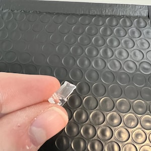 May include: A clear plastic clip with a curved shape.