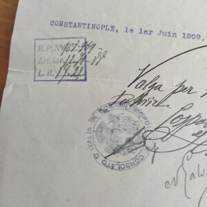 May include: A vintage document with handwritten text and stamps. The document is dated June 1, 1909, and includes the word "CONSTANTINOPLE." There are several stamps, including a blue rectangular stamp with text and numbers.