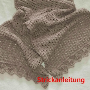 May include: A light brown crocheted shawl with a lacy pattern. The shawl is folded in half and has a scalloped edge. The text "Strickanleitung" is visible at the bottom of the image.