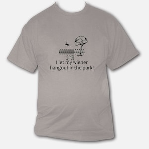 May include: A grey t-shirt with a black and white illustration of a dachshund in a wheelbarrow. The text "I let my wiener hangout in the park!" is printed below the illustration.