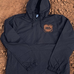 May include: Black hooded windbreaker with a brown patch on the front that says "SHARP 302M".