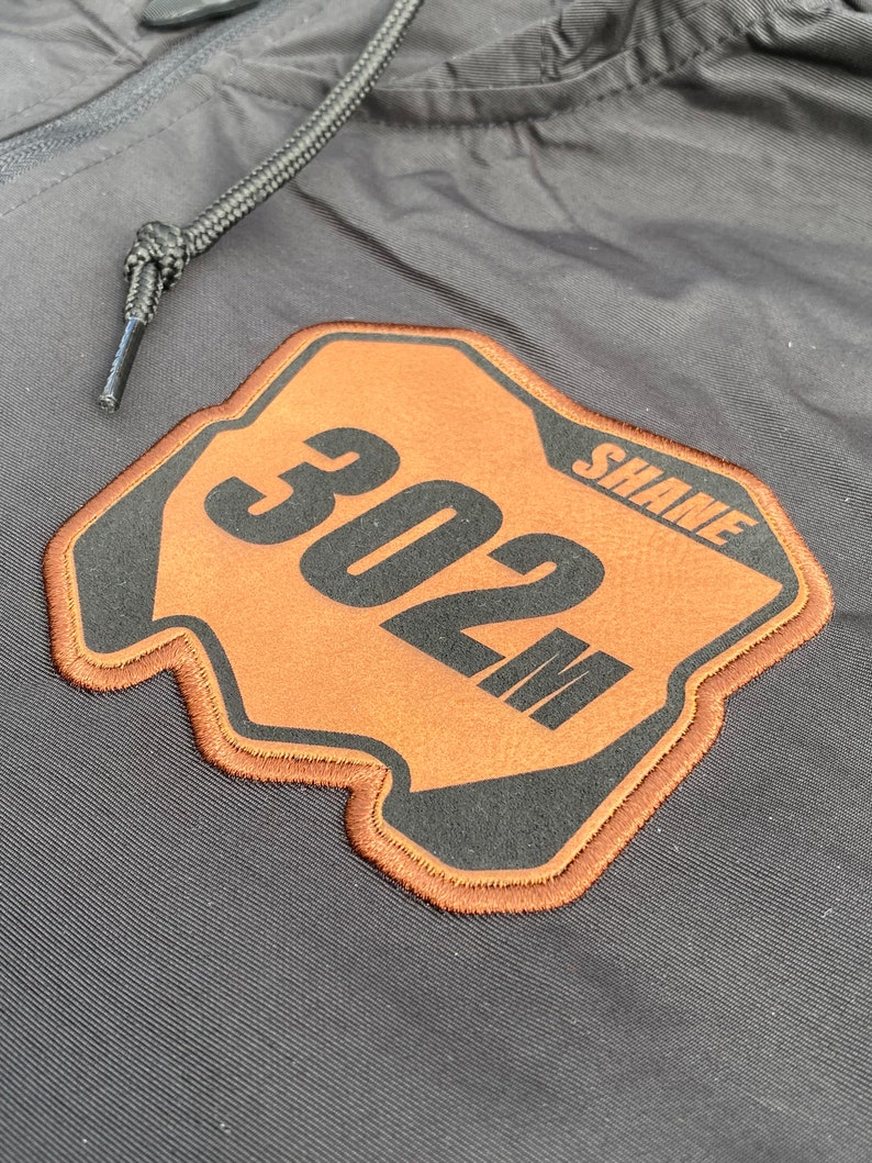 Close-up view of the laser engraved leatherette motocross number plate patch professionally embroidered onto the windbreaker.