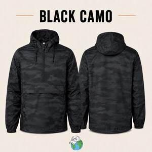 Puede incluir: Una chaqueta cortavientos tipo pullover en color negro con estampado de camuflaje, capucha con cordones, cierre de media cremallera y un bolsillo frontal horizontal. La imagen muestra la parte delantera y trasera con el texto BLACK CAMO.