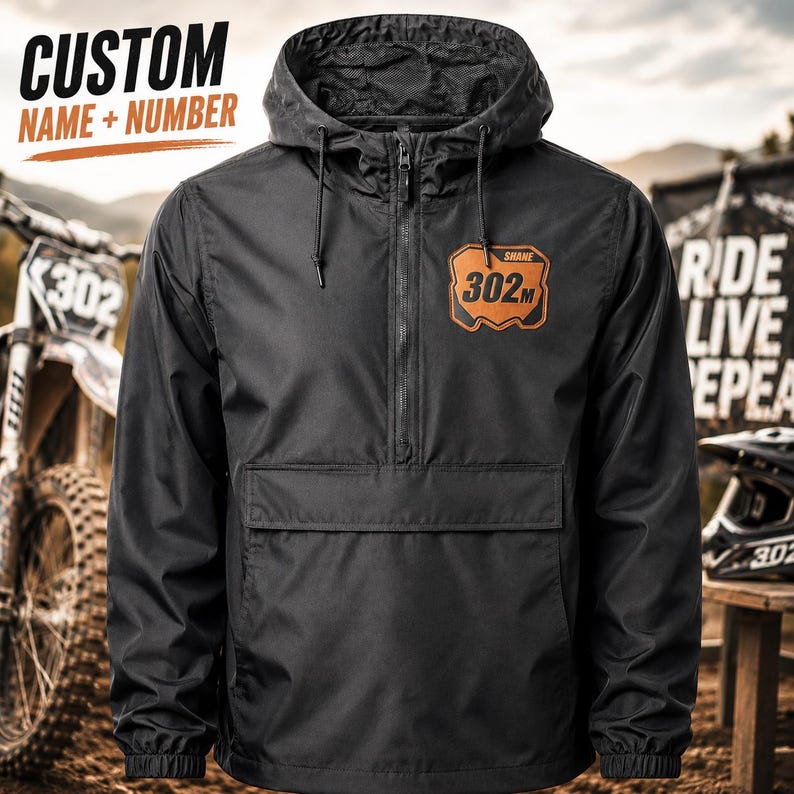 Personalized motocross windbreaker with custom leatherette number plate patch featuring your name and race number on a black lightweight riding jacket.