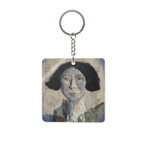 Può includere: Portachiavi quadrato con un ritratto artistico di una persona con capelli scuri e occhiali. L'opera d'arte ha un aspetto strutturato e misto con una tavolozza di colori tenui. Il portachiavi ha un anello e una catena color argento.