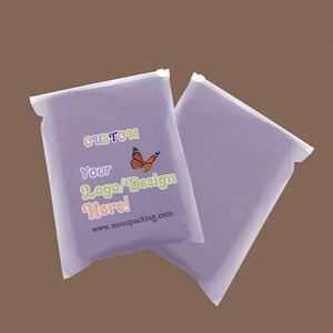 Puede incluir: Dos bolsas de plástico transparentes de color lavanda con cremalleras blancas. Una bolsa tiene las palabras "CUSTOM Your Logo/Design Here!" en texto colorido, un gráfico de mariposa y la dirección web www.monapacking.com.