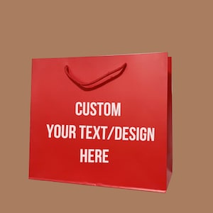 Puede incluir: Bolsa de papel roja con texto blanco que dice "CUSTOM YOUR TEXT/DESIGN HERE".