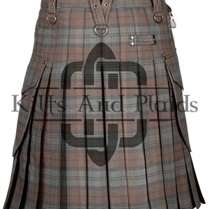 May include: A brown and gray plaid kilt with cargo pockets and a leather strap with buckles. The kilt has a D-ring on the front and a buckle on the side.