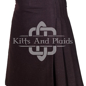 May include: A dark brown kilt with a belt and buckle. The kilt is pleated and has a simple design. The kilt is made of a thick, durable fabric. The kilt is a traditional Scottish garment.