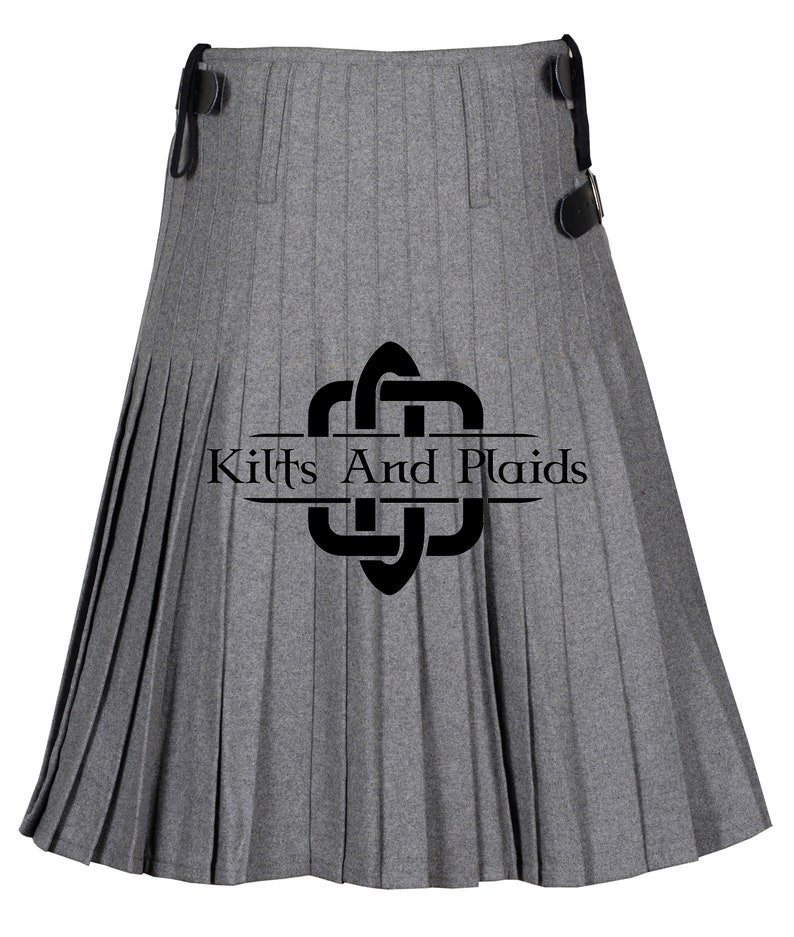 May include: A gray kilt with pleats and a black leather strap. The kilt has a black logo that says "Kilts And Plaids".