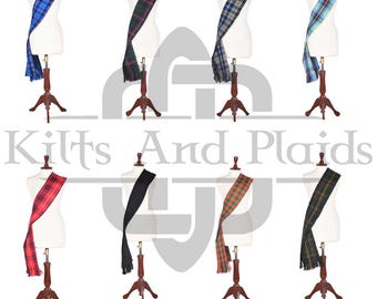 Op de afbeelding: Collectie geruite sjerpen in diverse kleuren, waaronder blauw, groen, rood en zwart, tentoongesteld op paspoppen. Elke sjerp heeft een gefranjerde rand en is over de pop gedrapeerd. De tekst "Kilts And Plaids" is zichtbaar.