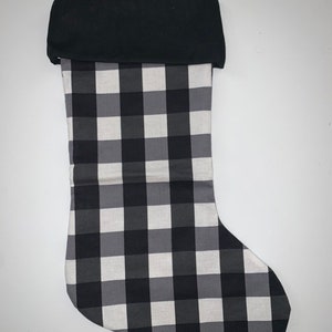 May include: Black and white buffalo plaid Christmas stocking with a black cuff.
