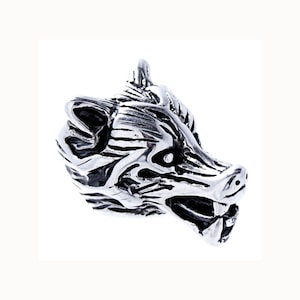 Könnte beinhalten: Ein silberner Wolfskopf-Anhänger mit detailliertem Fell und Zähnen. Der Anhänger ist aus Metall und hat ein realistisches Design.