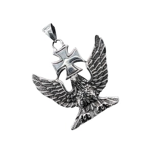 Op de afbeelding: Zilveren hanger met een gedetailleerd adelaarontwerp met een kruis op zijn rug. De adelaar heeft zijn vleugels gespreid en houdt het kruis vast met zijn klauwen.