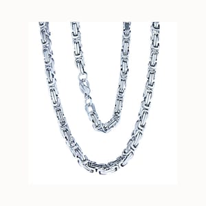 Puede incluir: Un collar de cadena de plata con un diseño de cadena de caja.