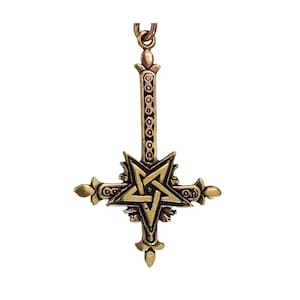 May include: A bronze-toned metal pendant featuring an inverted cross design with a central five-pointed star, or pentagram, integrated into the structure. The cross has ornate, pointed ends and a textured, patterned surface, suspended from a metal loop.