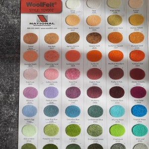 May include: Color chart of WoolFelt nonwovens, featuring a variety of felt colors. The chart includes a range of hues, from white and beige to pink, blue, and green. Each color is displayed as a small, round swatch with its name and code.