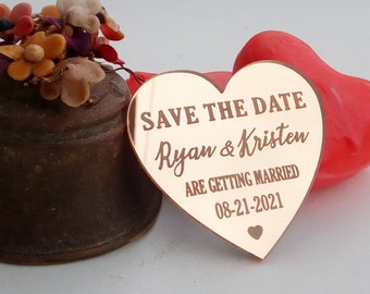 Può includere: Carta salva la data a forma di cuore in oro rosa con il testo "Save the Date Ryan & Kristen Are Getting Married 08-21-2021"