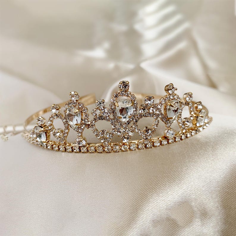 Gold kid rhinestone tiara with light beige background