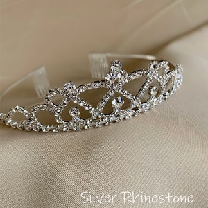 Pode incluir: Uma tiara prateada com strass transparentes. A tiara tem um design delicado e &eacute; perfeita para uma princesa.