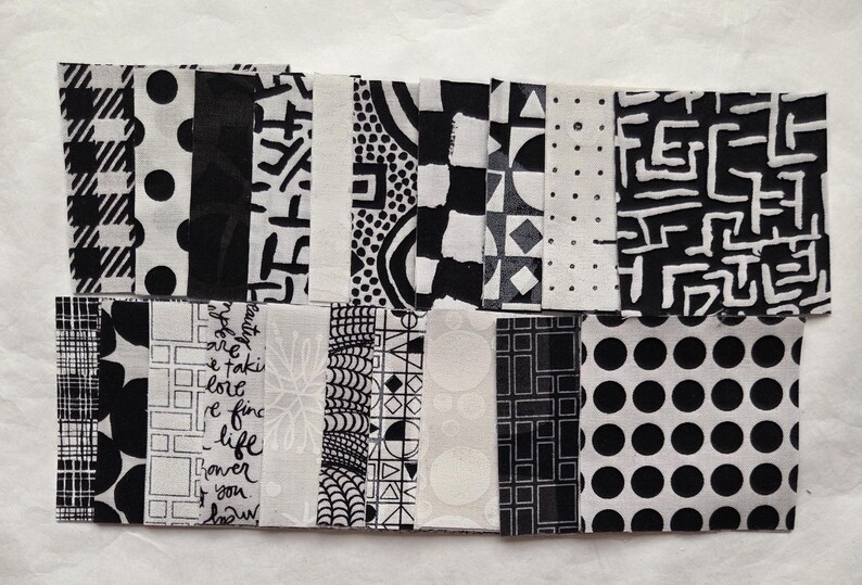 Pode incluir: Uma cole&ccedil;&atilde;o de amostras de tecido em preto e branco com v&aacute;rios padr&otilde;es, incluindo bolinhas, formas geom&eacute;tricas e desenhos abstratos. As amostras s&atilde;o dispostas lado a lado, mostrando uma variedade de texturas e interesse visual. O tema geral &eacute; moderno e gr&aacute;fico.