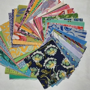 Puede incluir: Un conjunto de cuadrados de tela coloridos dispuestos en círculo. Los cuadrados presentan varios diseños florales, geométricos y abstractos en tonos azules, verdes, rosas, amarillos y morados. Ideal para proyectos de patchwork o manualidades.