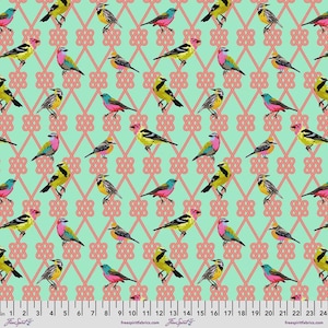 May include: A fabric pattern featuring colorful birds in yellow, pink, blue, and orange, set against a light green background. The birds are arranged within a repeating pattern of interlocking pink knots. The fabric has a ruler along the bottom edge.