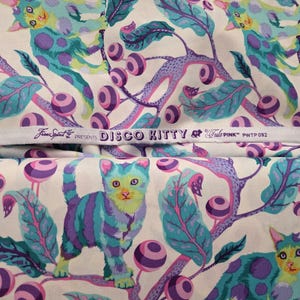 May include: Fabric with a whimsical pattern featuring stylized cats in teal, purple, and yellow, set against a cream background. The design includes leaves, berries, and the text "DISCO KITTY".