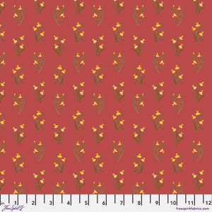 May include: A fabric with a repeating pattern of yellow daffodils with green stems and leaves on a red background. The fabric has a ruler along the bottom edge with measurements in inches. The words "Free Spirit" are in the bottom left corner.