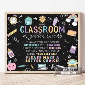 May include: A framed classroom sign with a black background and colorful illustrations. The text reads "Our Classroom Golden Rule" followed by a rule about learning and feelings. Includes a rainbow, apple, and school supplies.