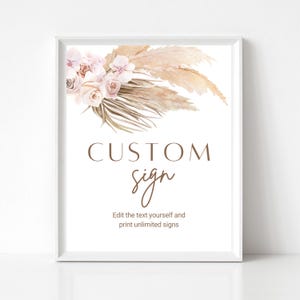 May include: A framed sign with a white background features the words "CUSTOM sign" in brown and a floral arrangement of pink and beige flowers. The text "Edit the text yourself and print unlimited signs" is below the main text.
