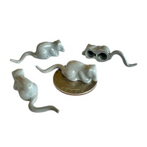 May include: Four gray plastic mice figurines, each with a different pose. The mice are about the size of a US quarter.