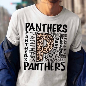 Op de afbeelding: Wit T-shirt met een luipaardprint letter "P" en het woord "Panthers" herhaald in zwarte tekst rond de letter.