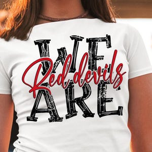 Puede incluir: Camiseta blanca con texto negro y rojo que dice "We Are Red Devils". El texto tiene un aspecto desgastado y vintage.