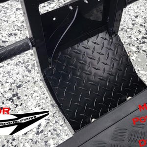 May include: Black metal back-up camera protector for a 2023/24 Evolution D5 Ranger. The protector is made with powder-coated aluminum diamond plate.