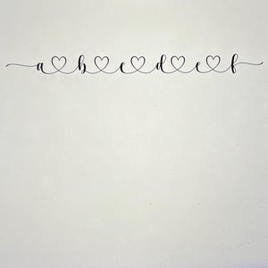 以下が含まれることがあります： a、b、c、d、e、fの文字が、それぞれハートマークで区切られた白黒の画像です。