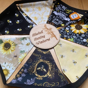 Bee Lovers Honey Hive Inspirational Quote Bee Kind Sunflower Black and Yellow Cotton Fabric Bunting by Bluebell Bunting. Small sized flags in a circle on the floor so that all flags can be seen closely at once.