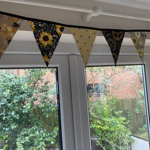 Bee Lovers Honey Hive Inspirational Quote Bee Kind Sunflower Black and Yellow Cotton Fabric Bunting by Bluebell Bunting. Small bunting draped from the curtain railing a window display.