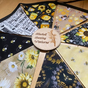 Bee Lovers Honey Hive Inspirational Quote Bee Kind Sunflower Black and Yellow Cotton Fabric Bunting by Bluebell Bunting. Medium sized flags in a circle on the floor so that all flags can be seen at once.