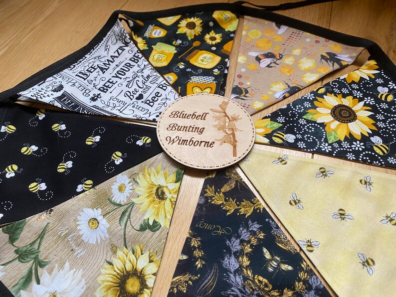 Bee Lovers Honey Hive Inspirational Quote Bee Kind Sunflower Black and Yellow Cotton Fabric Bunting by Bluebell Bunting. Medium sized flags in a circle on the floor so that all flags can be seen at once.