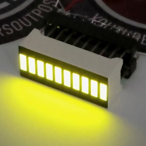 May include: A white LED bar with 10 yellow LEDs. The bar is mounted on a circuit board with pins for connection.