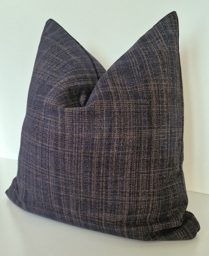 May include: A dark blue and brown patterned throw pillow with a textured fabric.