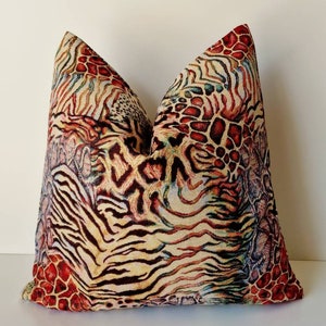May include: A decorative throw pillow with a colorful animal print design featuring zebra, leopard, and cheetah patterns in shades of brown, red, orange, and blue.