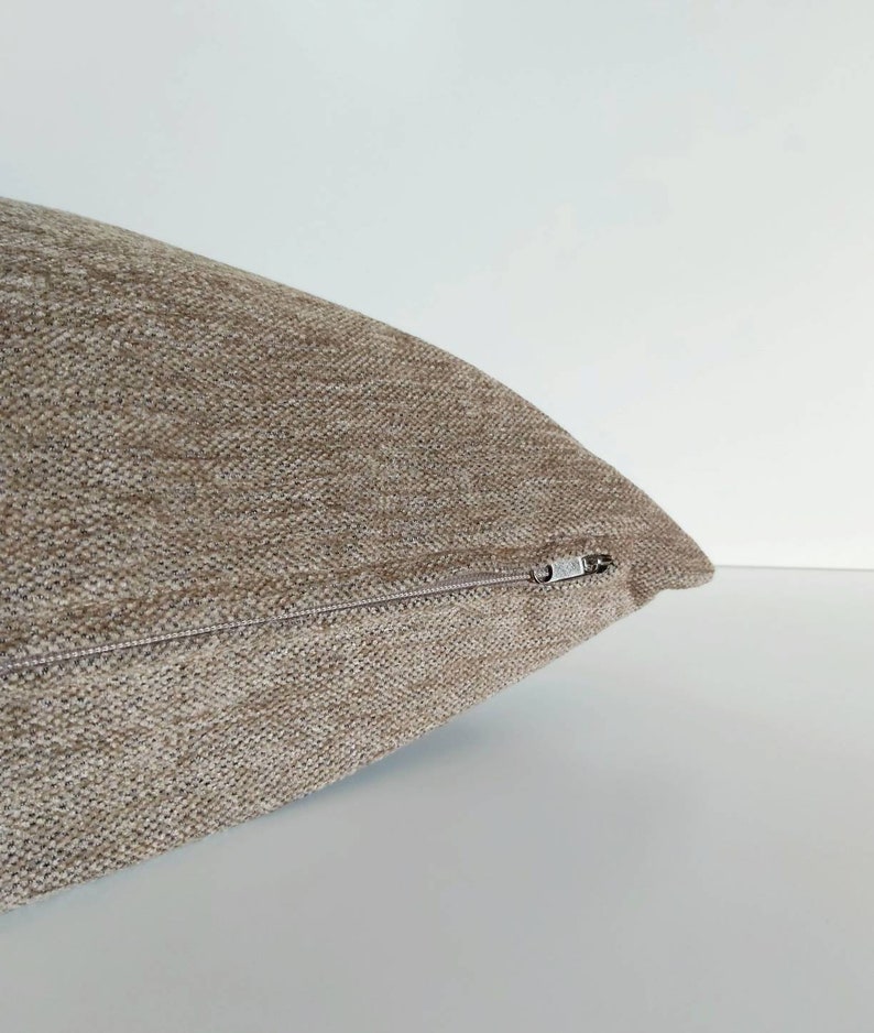 May include: A brown throw pillow with a zipper closure.