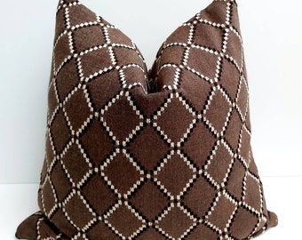 May include: A brown and white patterned throw pillow with a diamond design. The pillow is made of a soft, textured fabric.