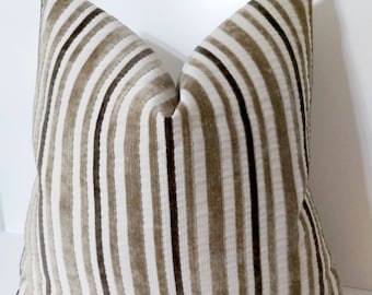 May include: A brown and white striped throw pillow with a velvet texture.